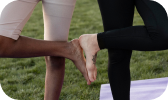 Two people leg-fiving during a workout